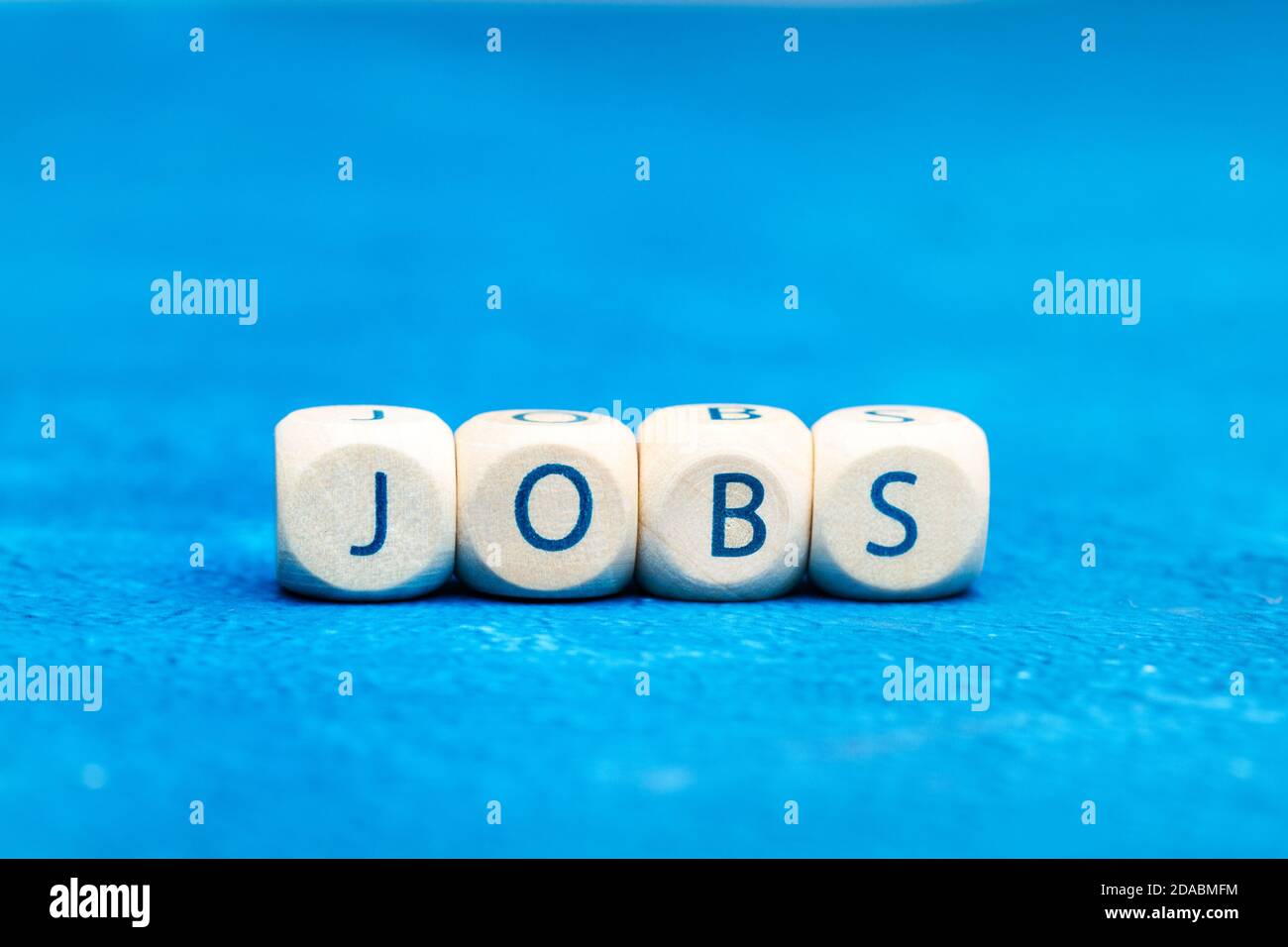 Jobs Wort mit Holzbuchstabenwürfel auf einem Klassiker gemacht Blauer Hintergrund Stockfoto