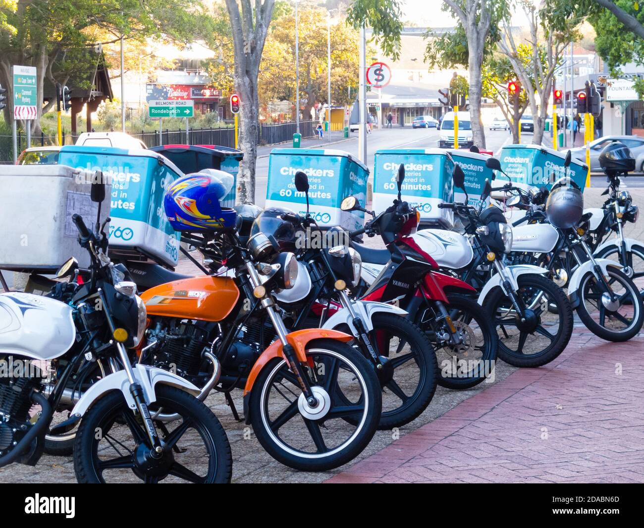 Motorräder, Lieferfahrräder auf einem Bürgersteig geparkt und von Checkers Supermarkt-Kette für die schnelle Lieferung von Lebensmitteln während der Sperre in Südafrika verwendet Stockfoto