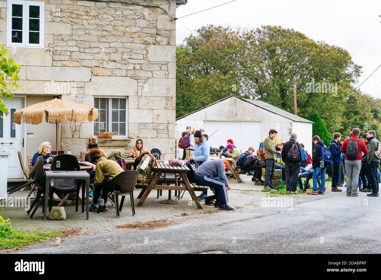 Pilger ruhen und essen auf der Terrasse des Hostel-Restaurant Casa Cruceiro von Ferreiros. Französischer Weg, Jakobsweg. Ferreiros, Concello de Paradela, Lu Stockfoto