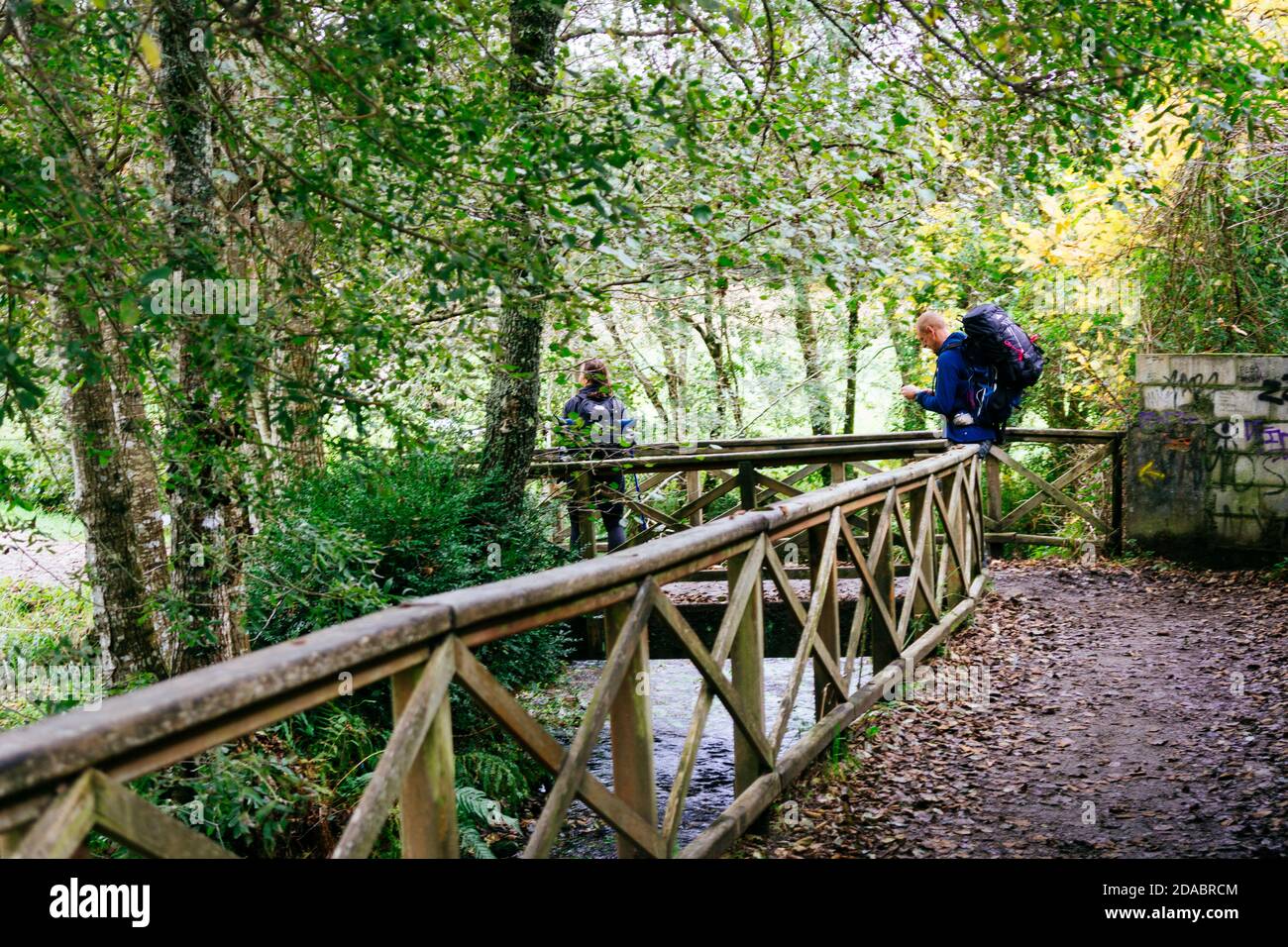 Pilger, die den Lavacolla Fluss überqueren. Französischer Weg, Jakobsweg. Lavacolla, Santiago de Compostela, A Coruña, Galicien, Spanien, Europa Stockfoto