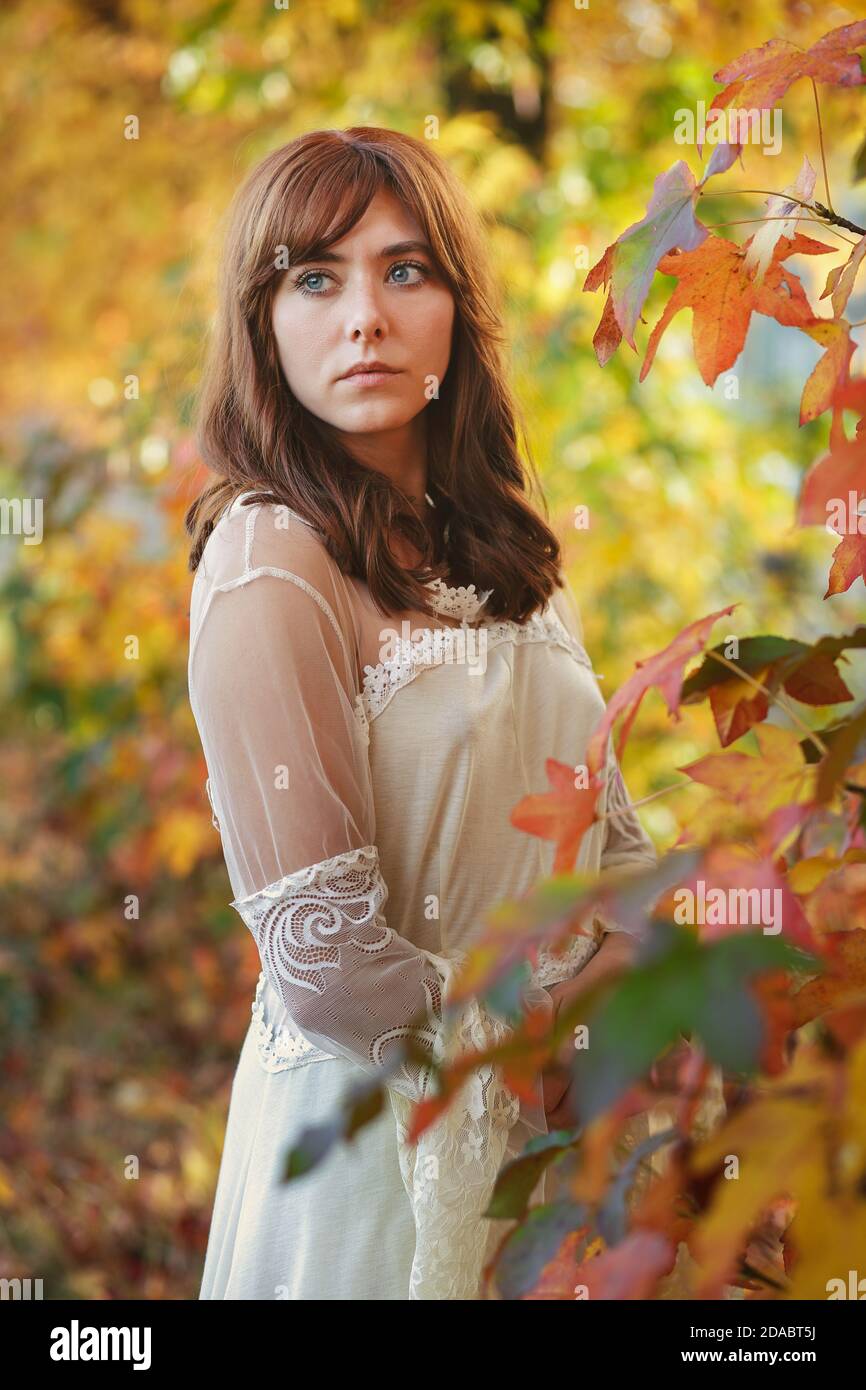 Schöne Frau unter Herbstblättern. Farbenfrohes Porträt Stockfoto