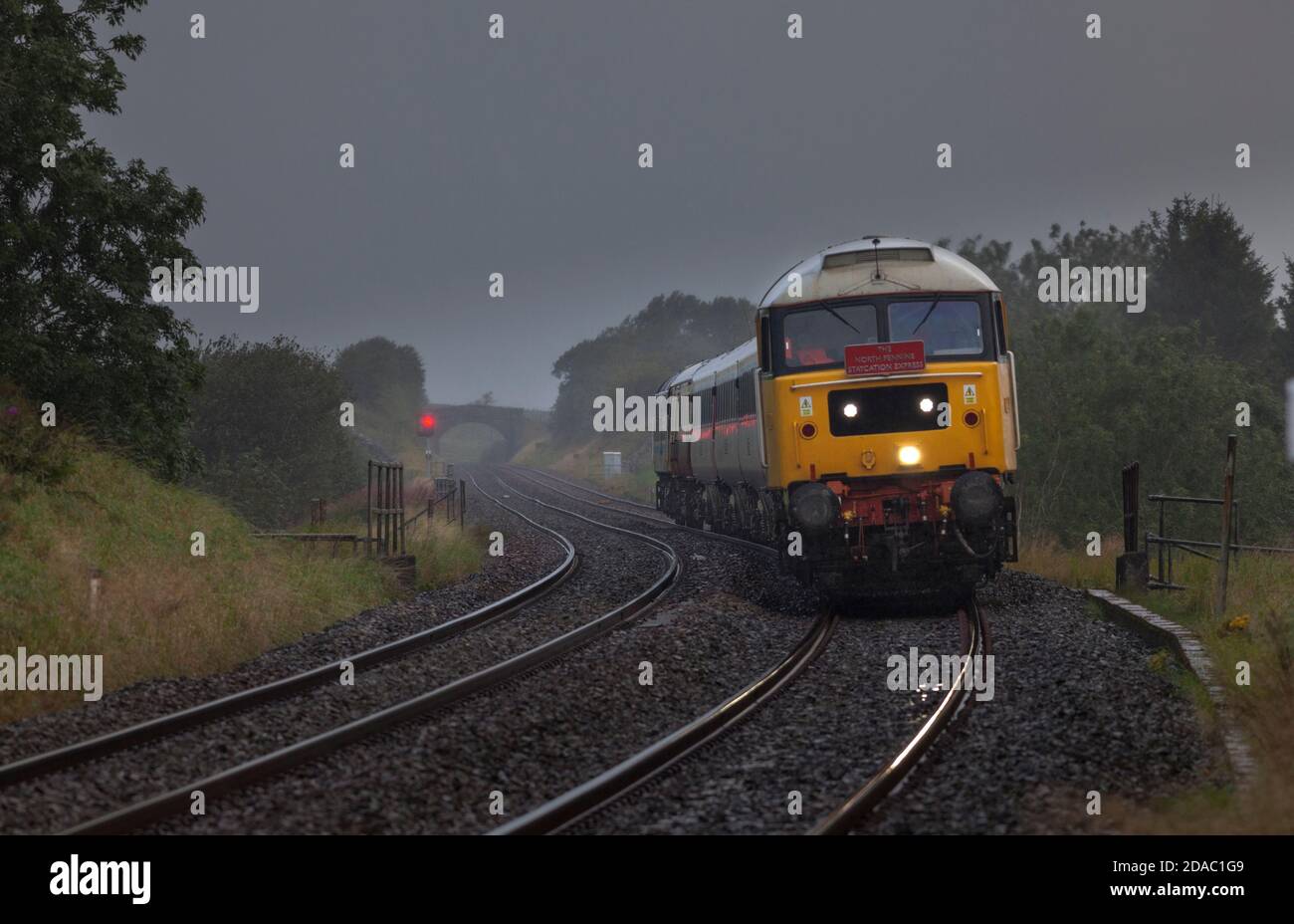 Lokomotive der Baureihe 47 47593, die den 'Staycation Express'-Wagen mitschleppt Ein sehr nasser regnerischer Ort und Carlisle Eisenbahn in Horton In Ribblesdale Stockfoto