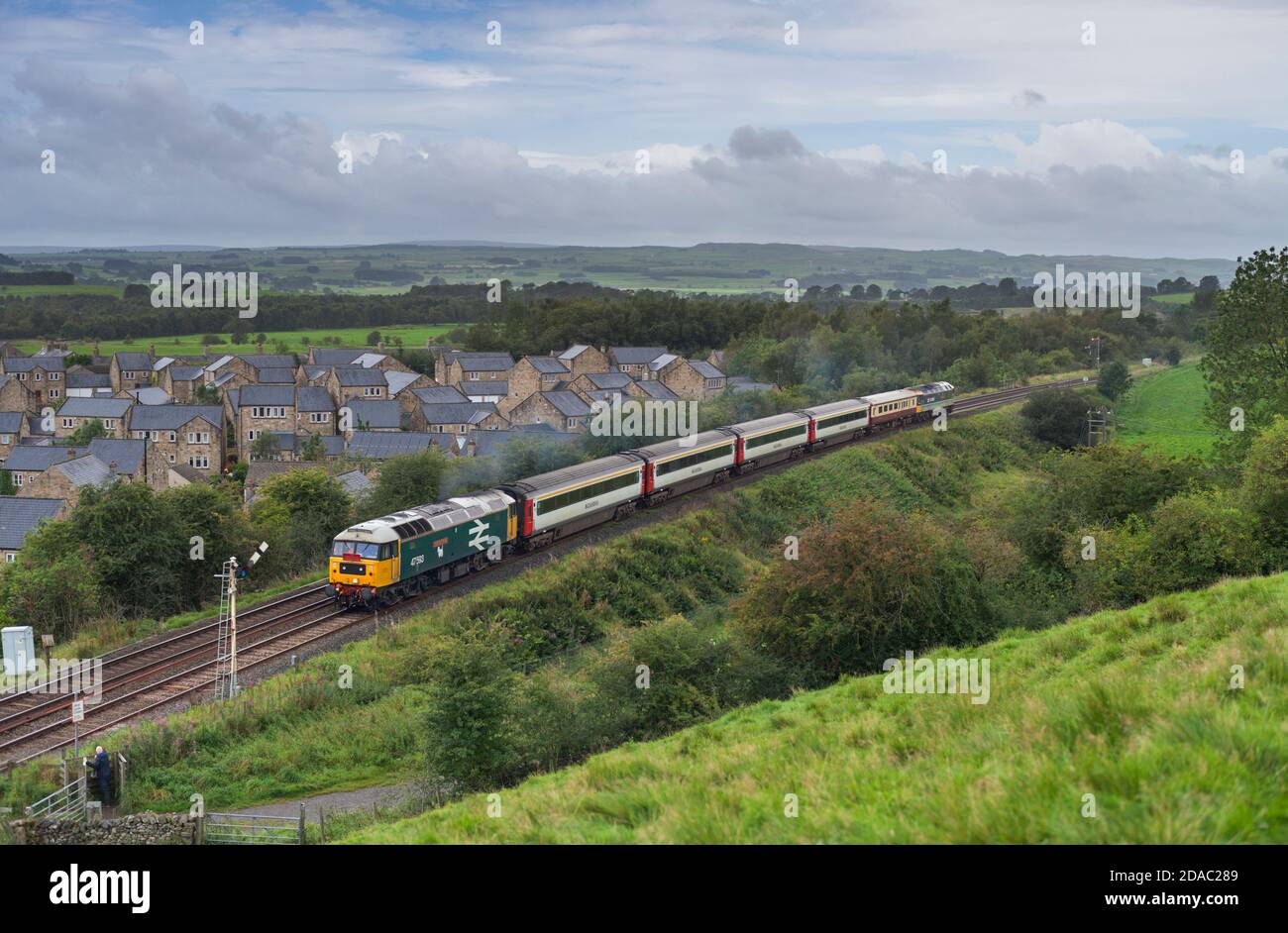 Lokomotive der Baureihe 47 47593, die ein mechanisches Semaphore-Signal bei passiert Hellifield mit einem 'Staycation Express' Charterzug Stockfoto
