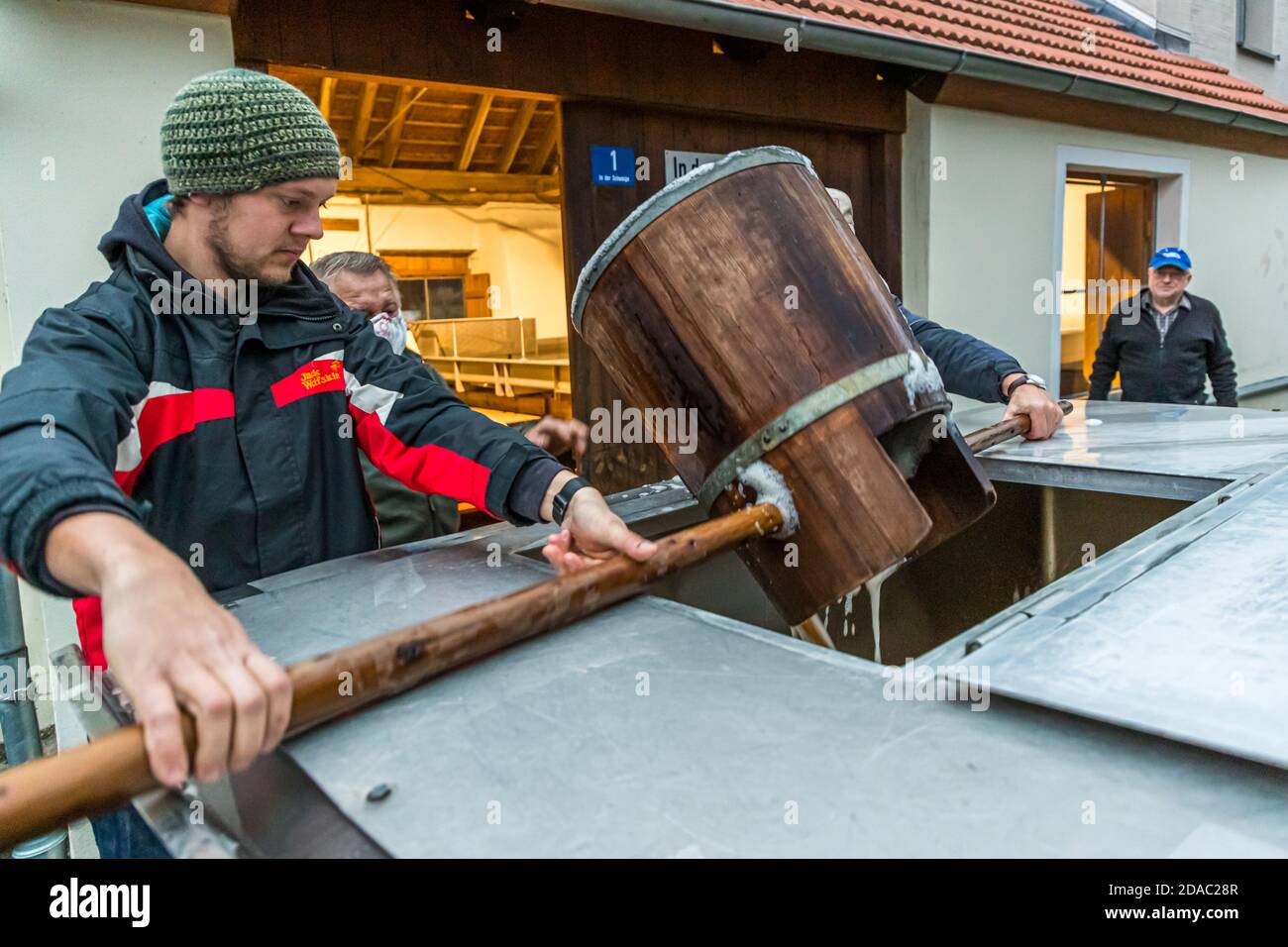 Traditionelle Zoigl Brauerei. Die Zoigl Original-Würze wird mit traditionellen Holzeimern in Falkenberg, Deutschland, lebhaft in den Tanker gefüllt Stockfoto