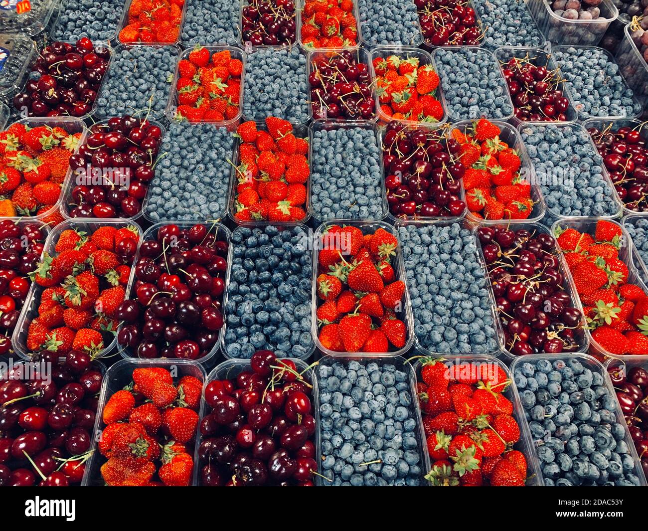 Früchte schöne diagonale Layout Hintergrund in Kunststoff-Boxen Körbe, Draufsicht auf Sommer Bio-Lebensmittel - Erdbeeren, Heidelbeeren, süße Kirschen an Stockfoto