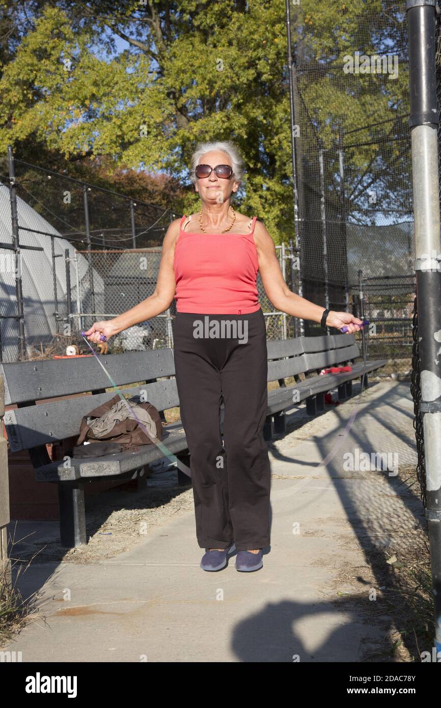 70-jährige Frau bleibt in guter Form springen Rumping im Park in Brooklyn, New York. Stockfoto