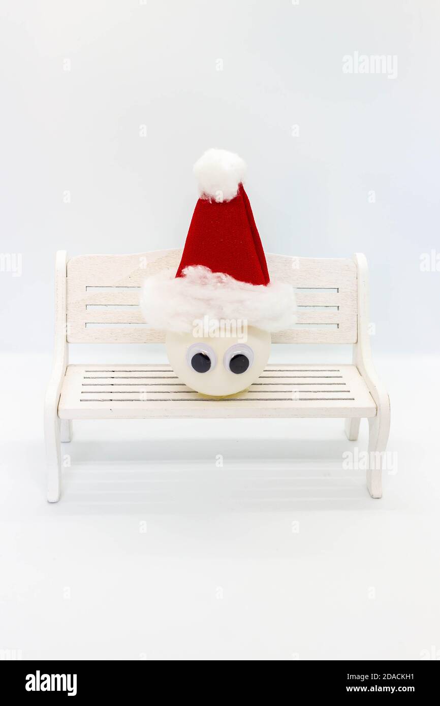 Schneemann aus einem Ball auf einer Banch auf weiß Hintergrund.Winter Weihnachtsfeiertagskonzept Stockfoto