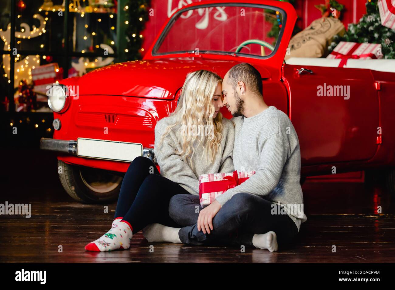 Portrait von glücklich liebenden Paar schaut sich gegenseitig auf Heiligabend auf Weihnachten Hintergrund. Frohe Weihnachten! Stockfoto