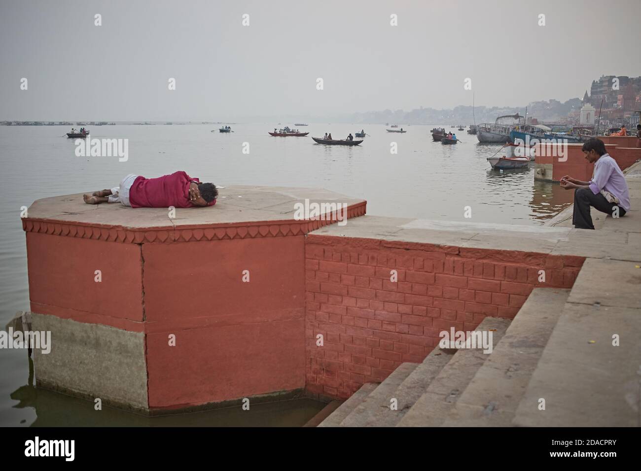 Varanasi, Indien, November 2015. Ein Mann schläft in einem Ghat am Ganges. Stockfoto