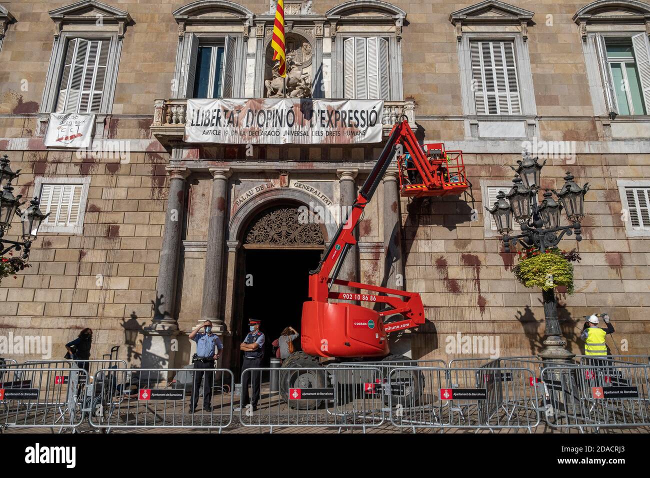 Ein Kran vor der Fassade zu sehen.Reinigungsarbeiten an der historischen façade im Palast der Generalitat de Catalunya nach einer schnellen Protestaktion von einer Gruppe von weniger als 10 Menschen, die Ballons mit roter Farbe und Blut geworfen und die Wiedereröffnung fordern vermasselt vermasselt Bars und Restaurants, die aufgrund von Covid-19-Infektionen obligatorisch geschlossen sind. Stockfoto