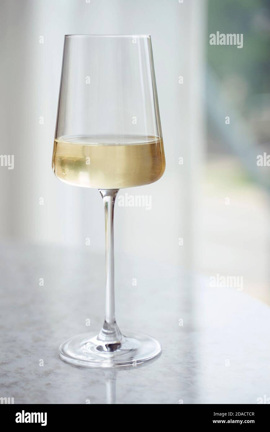 Ein Glas Weißwein auf einem Marmortisch. Stockfoto