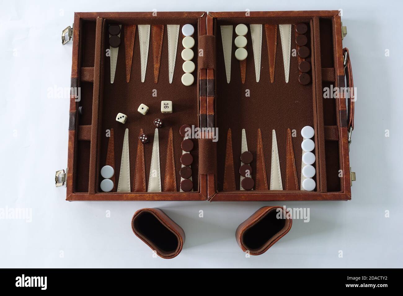 Ein Backgammon-Set, das für zwei Personen auf weißem Hintergrund gespielt werden kann. Stockfoto