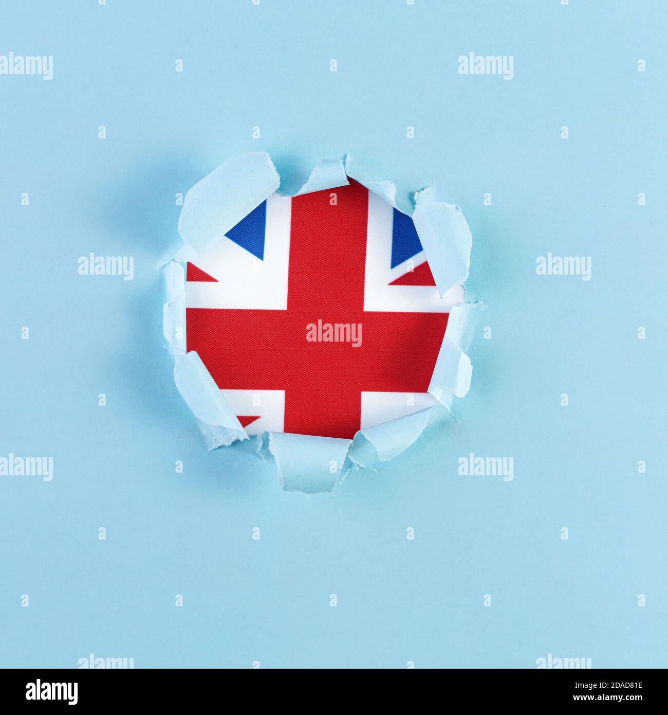 Zerrissenes Papier gefüllt mit englischer Flagge aus blauem Papier. Reisekonzept mit UK Flagge Hintergrund. Bildung und Wirtschaft Stockfoto