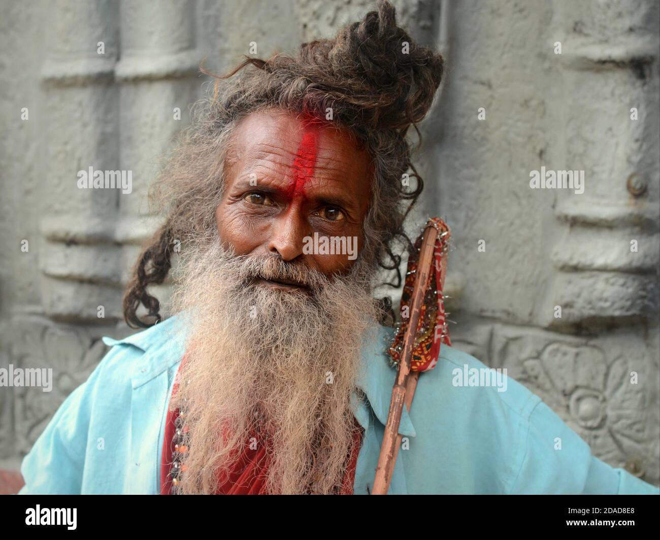 Alter indischer Hindu Sadhu / Pilger mit grauem Brötchen, langem grauem Bart und roter Tilak-Markierung auf der Stirn posiert für die Kamera während des Navratri-Festivals. Stockfoto