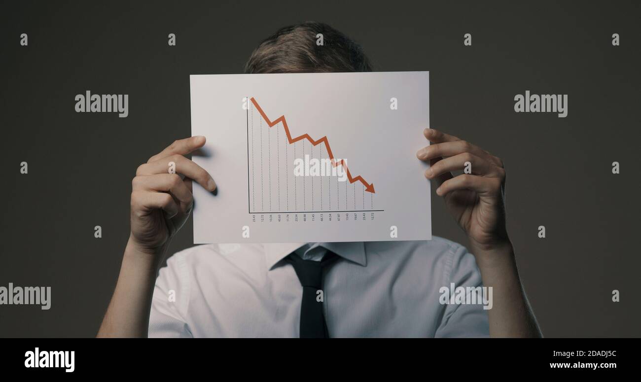 Geschäftsmann mit einem negativen Finanzdiagramm, Konkurs und Finanzkrise Konzept Stockfoto