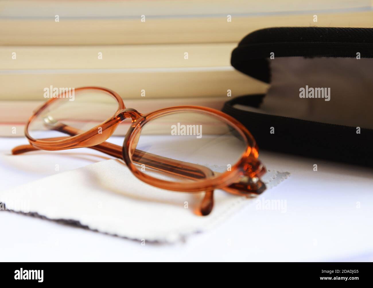 Brillen mit schwarzem Etui und Tuch vor mehreren Bücher Stockfoto