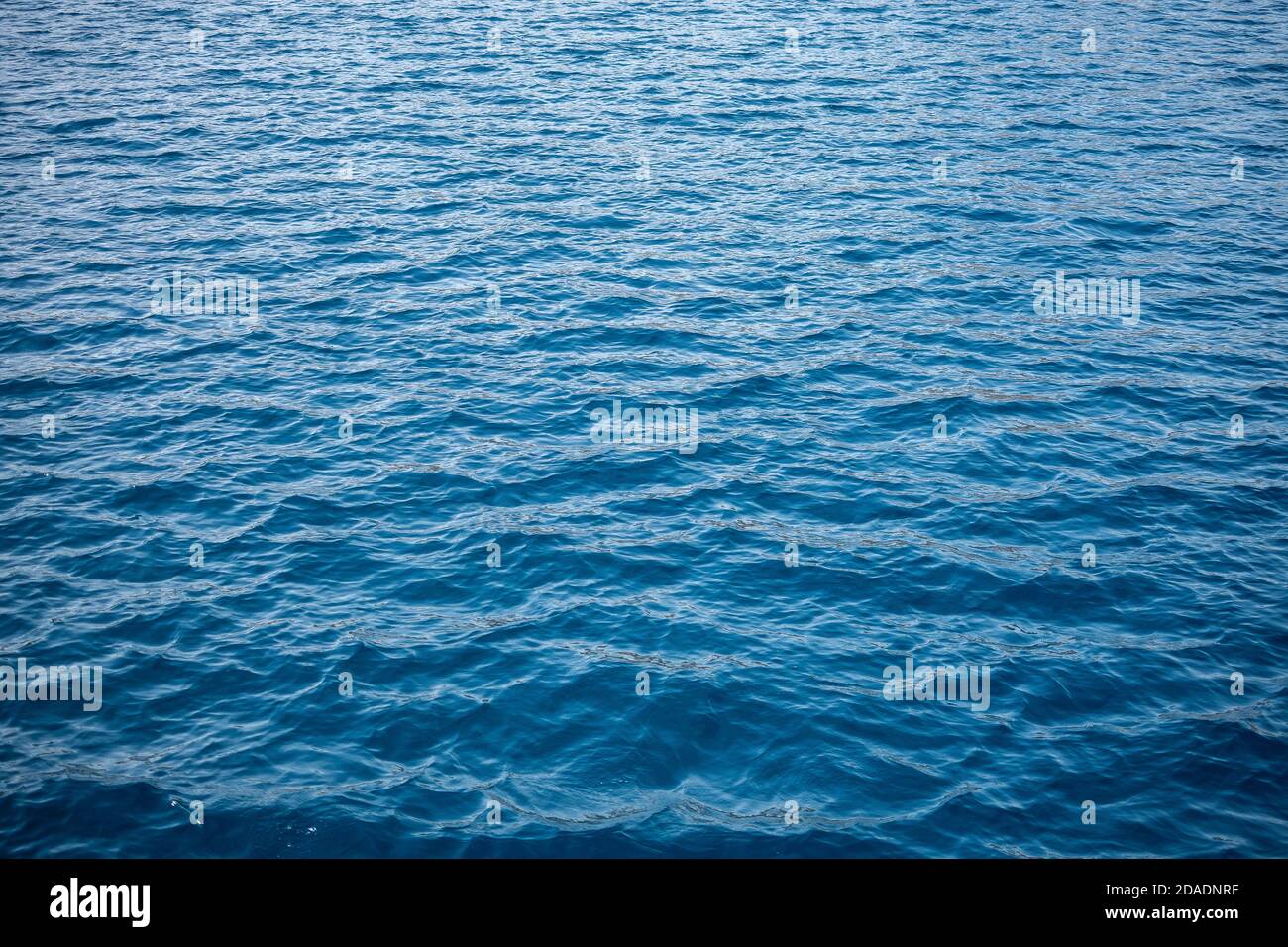 Blaues Meer Wasser Hintergrund Textur. Blaues Meerwasser mit Wellen Hintergrund. Weiche blaue Wellen - Wasseroberfläche auf dem Meer Stockfoto