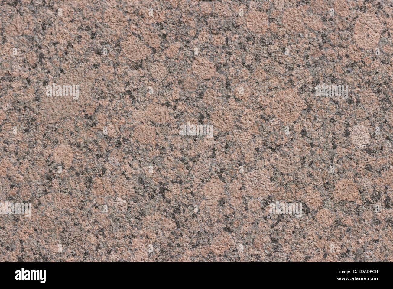Die Textur einer bunt gesprenkelten polierten Marmorplatte. Stockfoto
