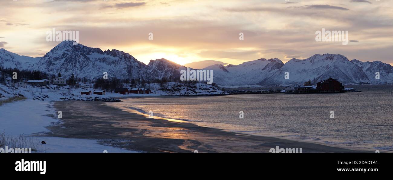 Kalte Winterlandschaften mit schneebedeckten Bergen bei Sonnenuntergang auf der Insel Senja in den Lofoten, Norwegen. Stockfoto