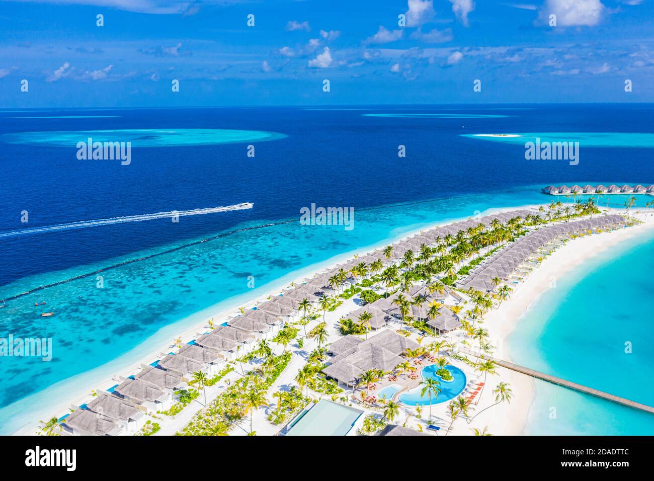 Luftaufnahme einer tropischen Insel im türkisfarbenen Wasser. Luxuriöse Villen über dem Wasser auf tropischen Insel Resort. Malediven Luftbild Landschaft Urlaub Stockfoto