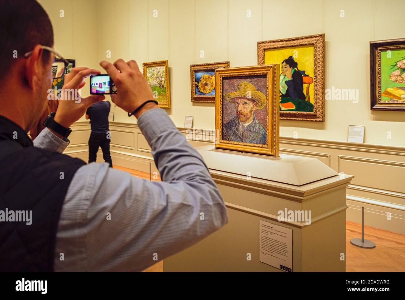 Besucher fotografiert Vincent Van Goghs Gemälde von 1887, Selbstporträt mit Strohhut. Ausgestellt im Metropilitan Museum of Art, New York City, N Stockfoto