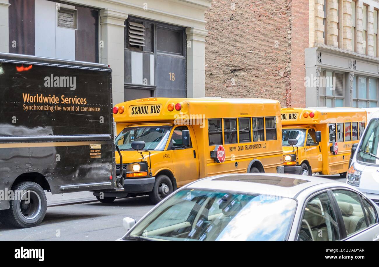 Zwei gelbe Schulbusse in einer Reihe in einem geparkt Manhattan Nachbarschaft Stockfoto
