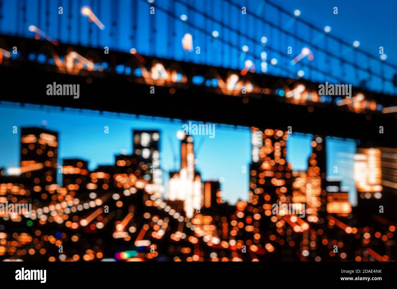Verschwommene Lichter der Skyline von Manhattan und der Manhattan Bridge bei Nacht. Manhattan Bridge ist eine Hängebrücke, die den East River in New York Cit überquert Stockfoto