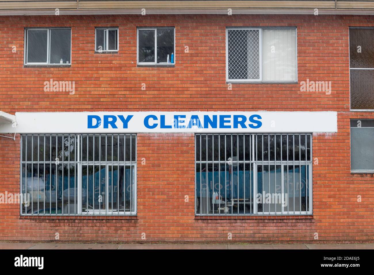 Die Seite eines Dry Cleaners-Ladens in Forster, New South Wales, mit Stahlsicherheitsriegeln an den Fenstern im Erdgeschoss Stockfoto