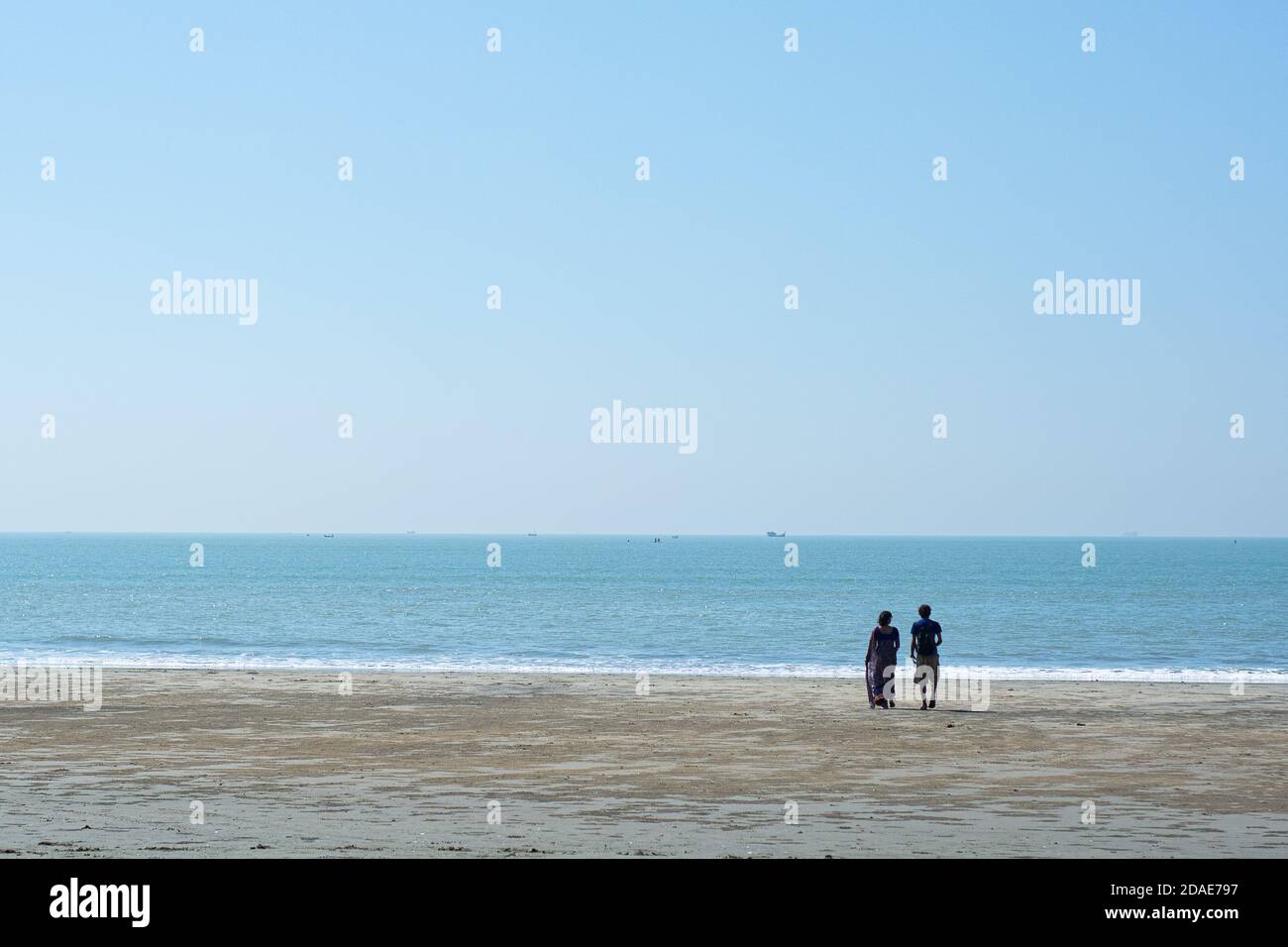 Romantisches Paar in den Flitterwochen, das im Sommer an einem Strand an einem tropischen Reiseziel entlang läuft Stockfoto