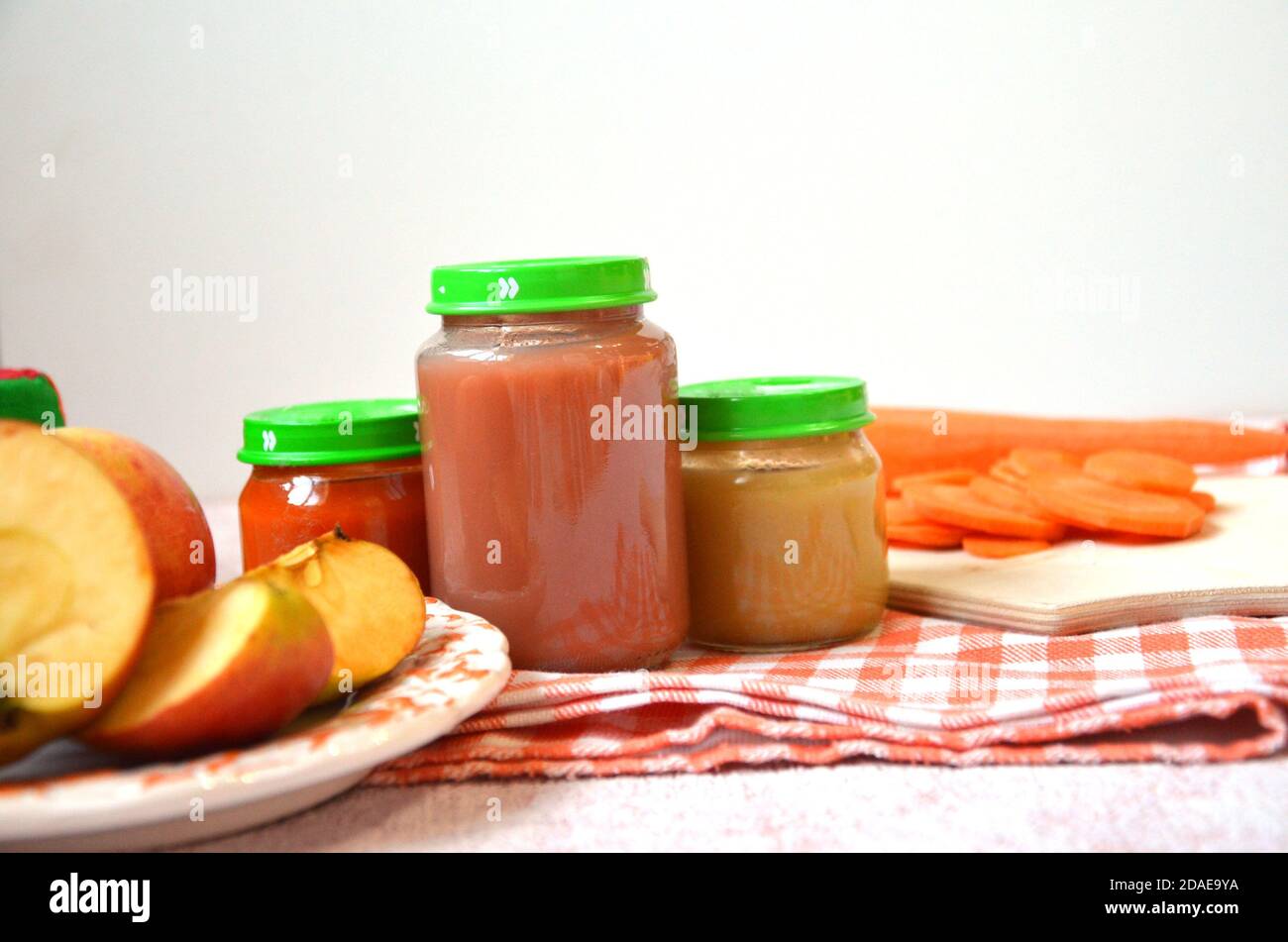 Babynahrung, Baby in einem Glas püriert, in Scheiben geschnittene Karottenscheiben, Apfel Stockfoto