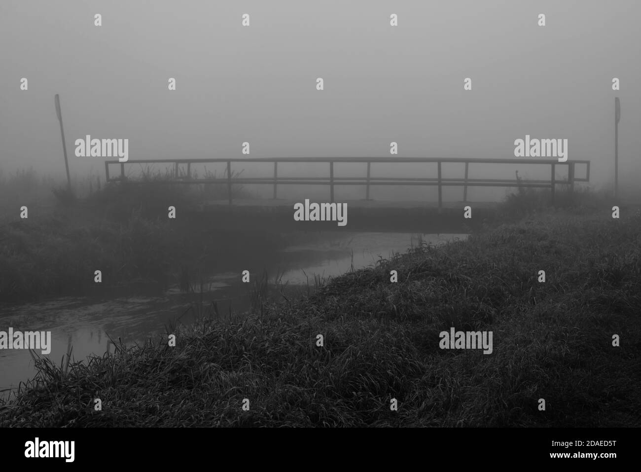 Nebel über einem kleinen Fluss mit Brücke, selektive Schärfe, Schärfe im Vordergrund Stockfoto