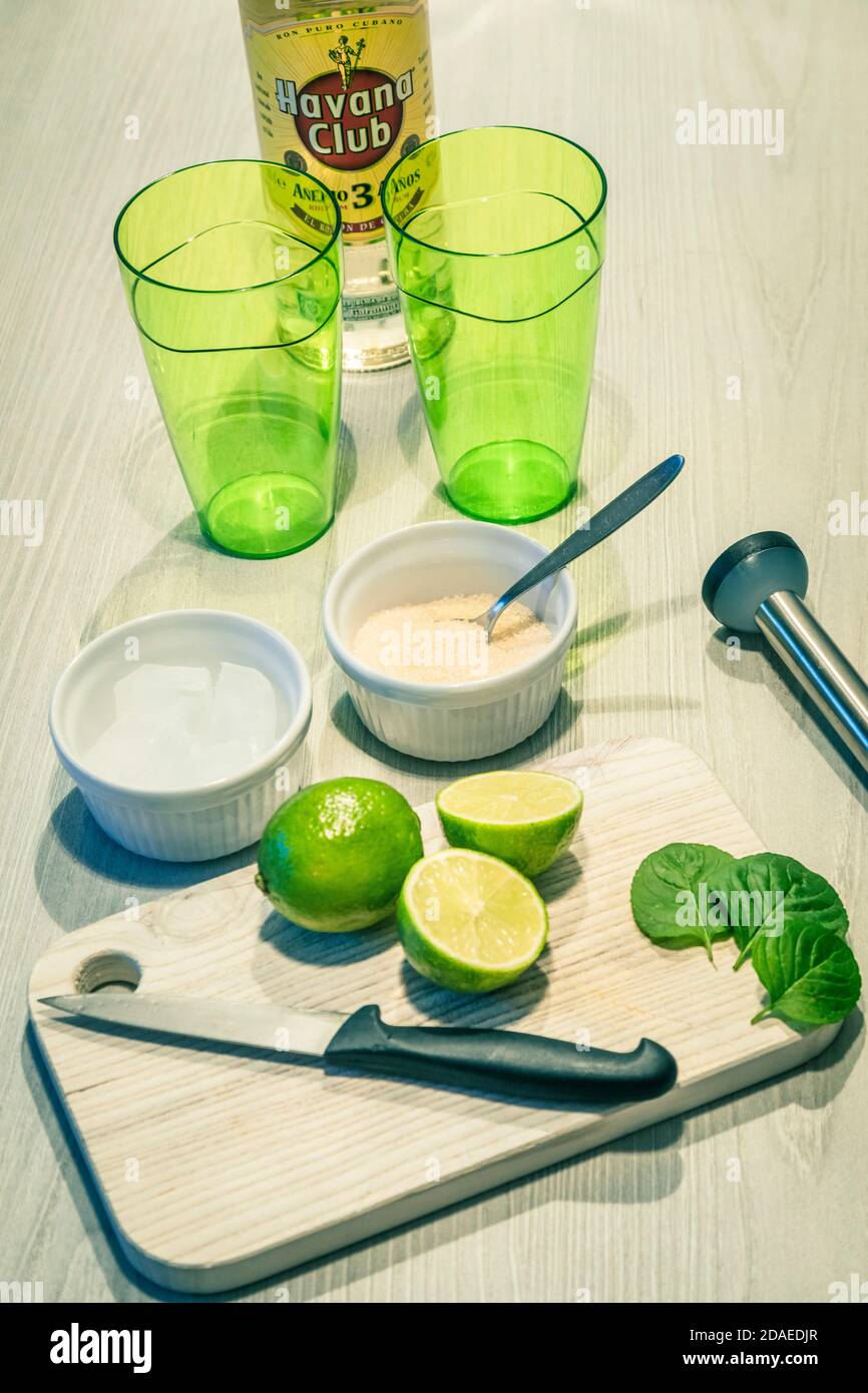 Zubereitung eines Mojito-Cocktails, Zutaten auf einem Holztisch und ein paar grüne Gläser Stockfoto