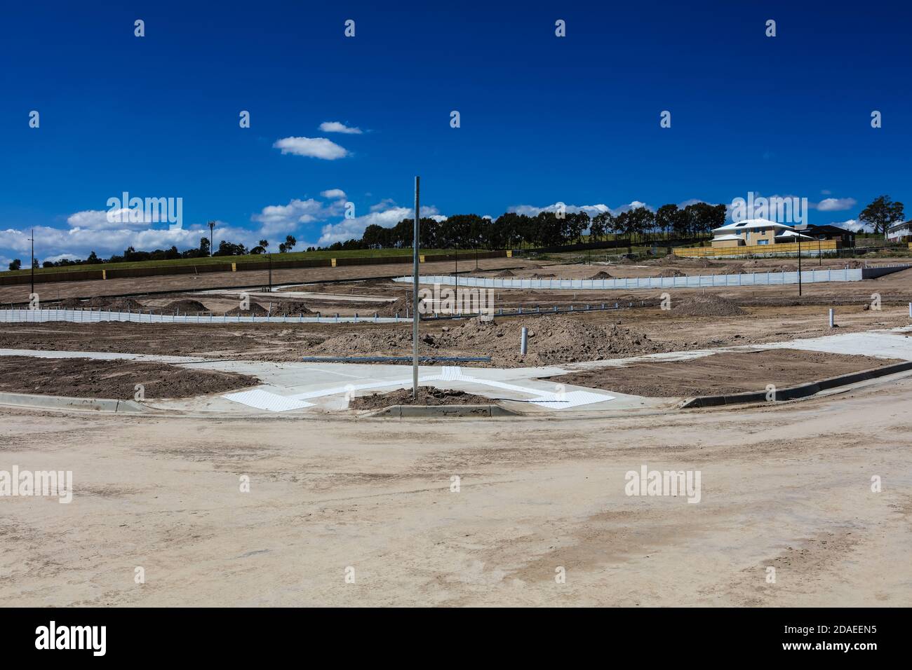 Am Stadtrand von Melbourne Australien wird ein neues Anwesen gebaut, schwere Maschinen haben den Hang terraformt, Straßen wurden verlegt. Stockfoto