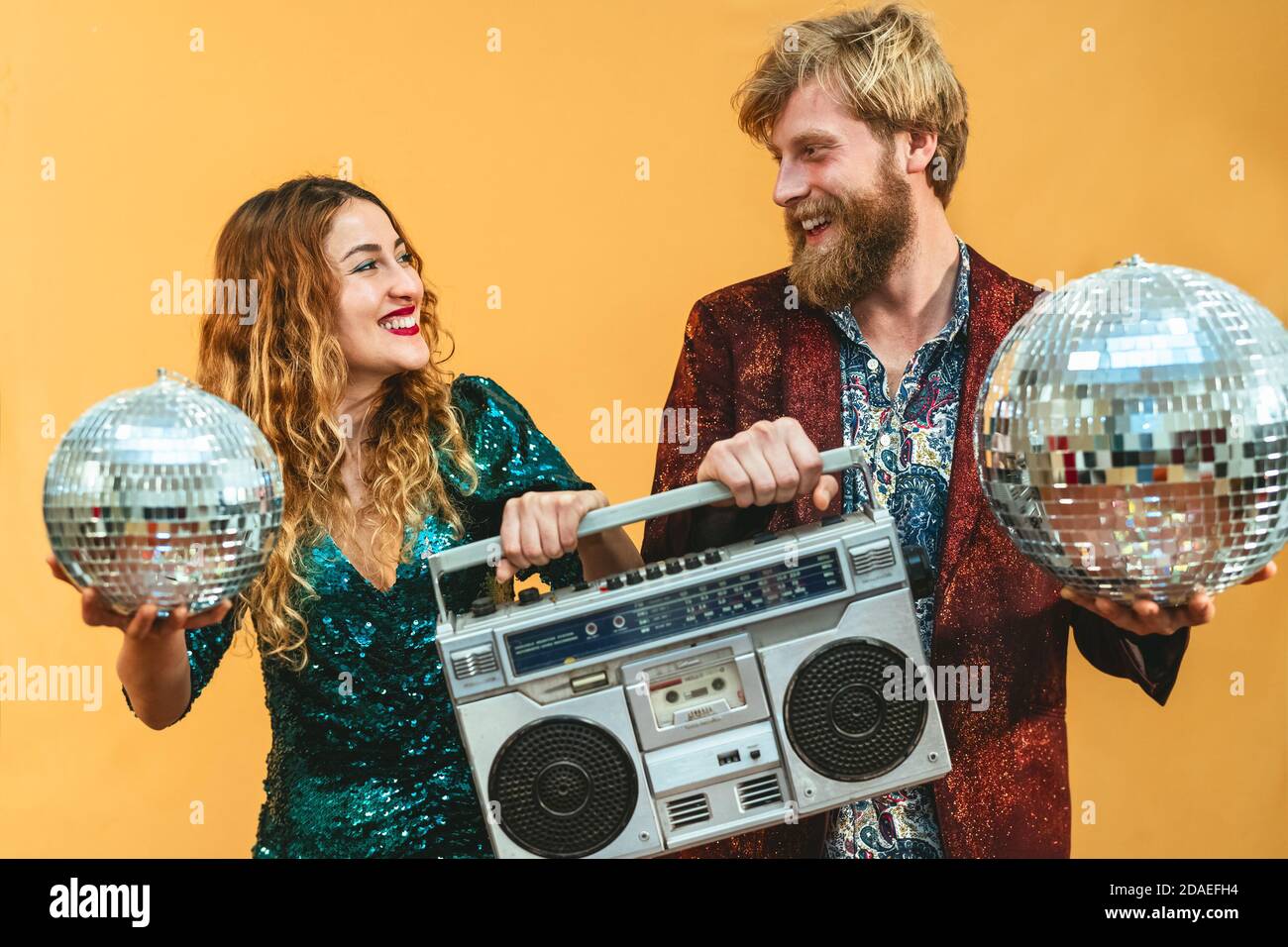 Fröhliches junges Paar feiert Feiertage und hört Musik mit Vintage-Boombox Stockfoto