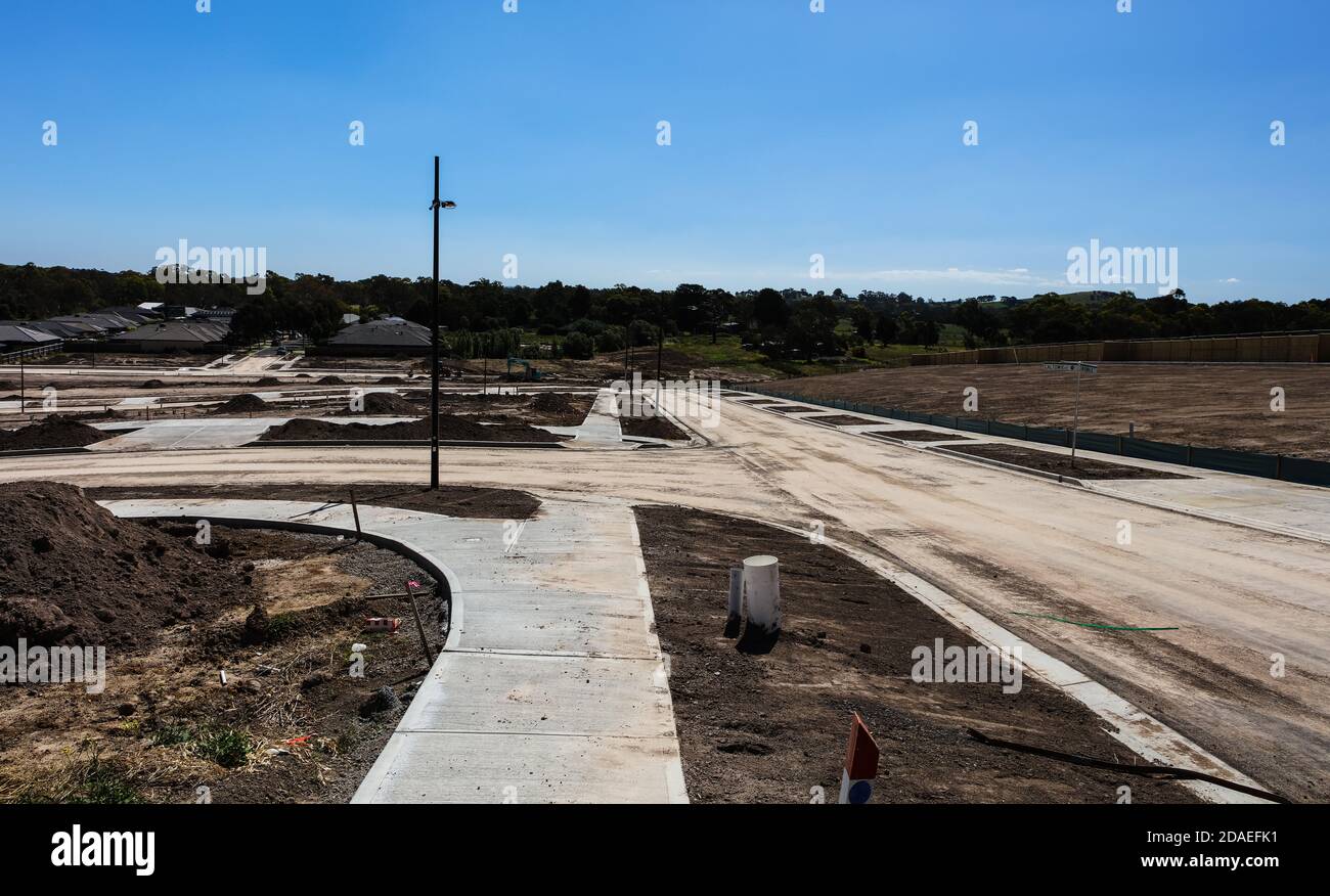 Am Stadtrand von Melbourne Australien wird ein neues Anwesen gebaut, schwere Maschinen haben den Hang terraformt, Straßen wurden verlegt. Stockfoto