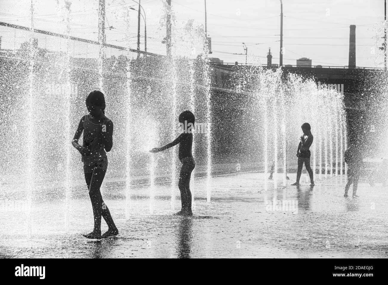 KIEW, UKRAINE - 29. Juli 2020: Kinder spielen in einem Brunnen und genießen die kühlen Wasserströme an einem heißen Tag. Heißer Sommer. Springbrunnen in der Nähe des Th Stockfoto