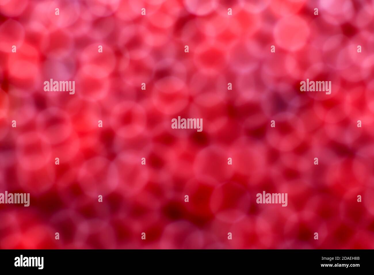 Der Hintergrund ist rot, unfokusiert. Bokeh sieht aus wie Blutkörperchen, flache Körper, Erythrozyten. Stockfoto