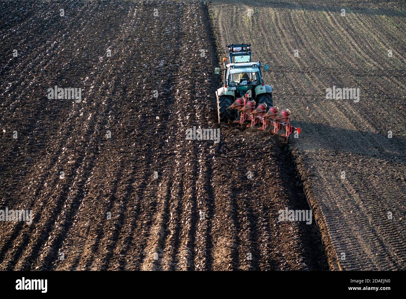 Bauer pflügt ein Feld, Traktor mit Pflug, bei Neuss, NRW, Deutschland Stockfoto