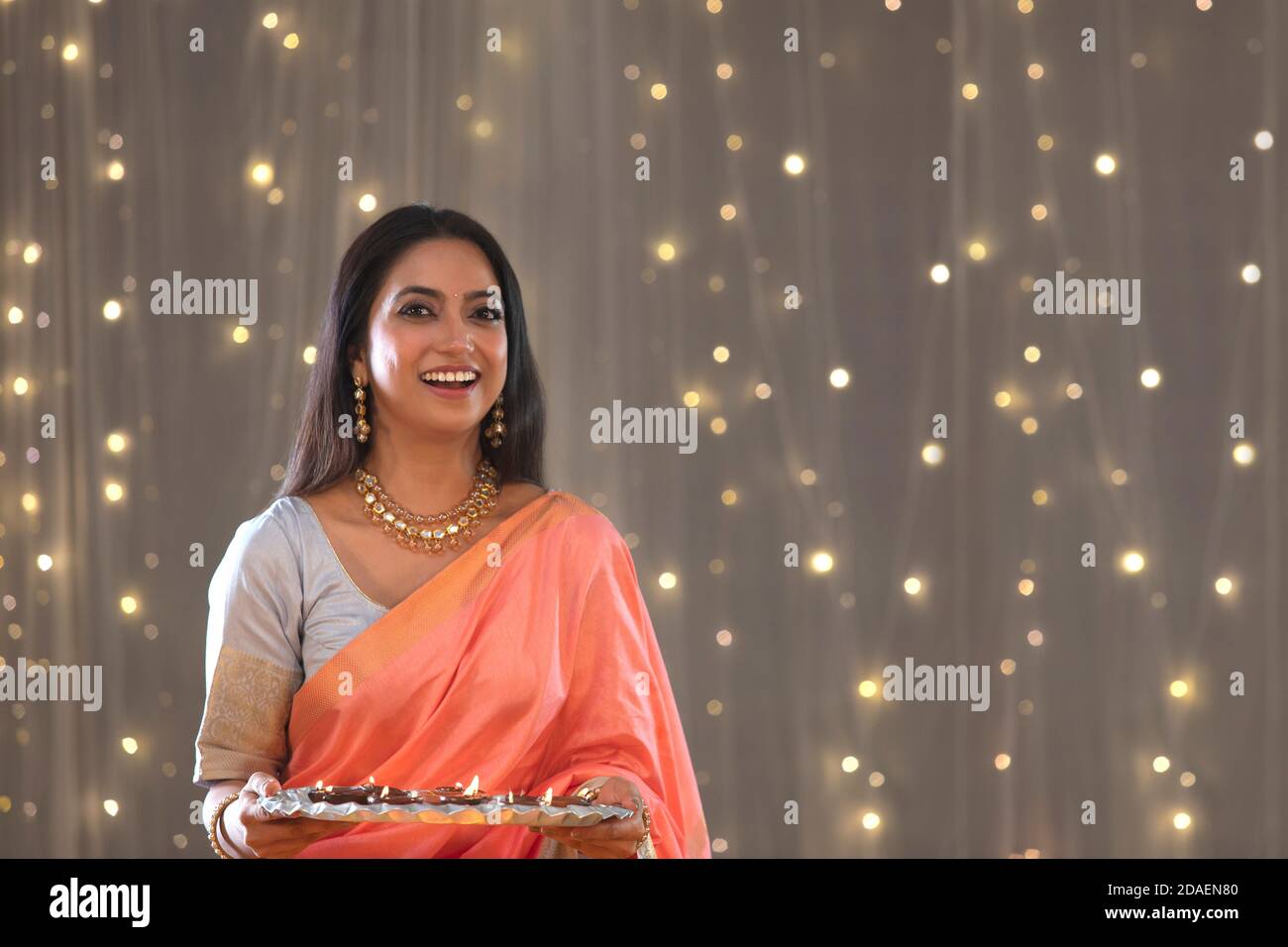 Frau im mittleren Alter hält Diyas und lächelt hell Stockfoto