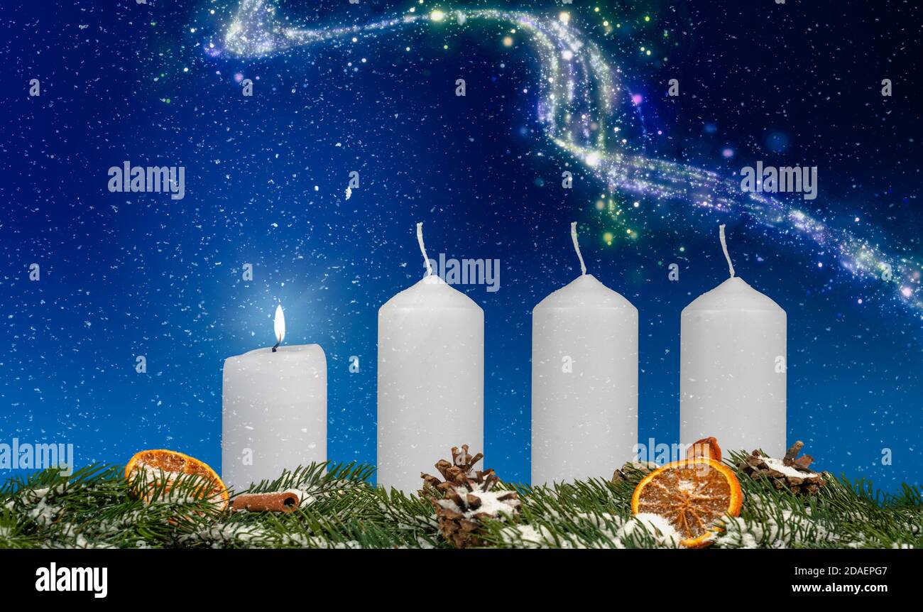 Eine Kerze auf einem Adventskranz brennt mit blauem Hintergrund Und Schnee Stockfoto