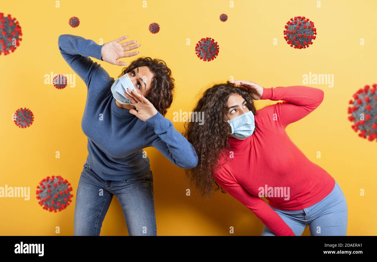 Freunde sind umgeben von Viren und Bakterien. Konzept der Coronavirus covid-19 Pandemie. Gelber Hintergrund Stockfoto