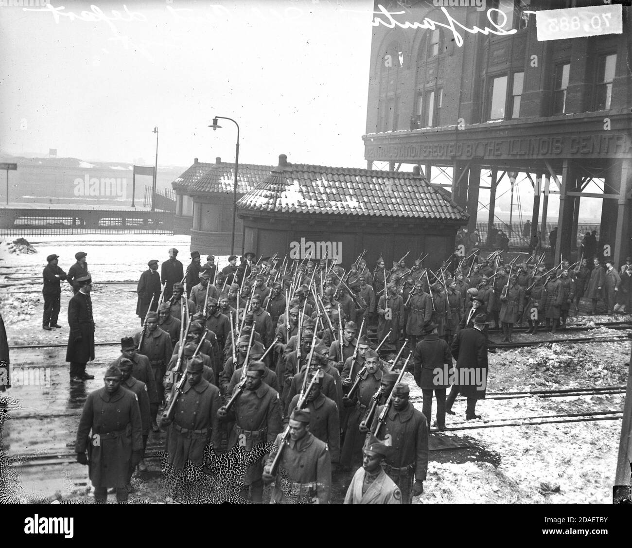 Blick auf die 365. Infanterie, eine afroamerikanische Infanterie, die mit Gewehren an der Illinois Central Railroad Station, Chicago, Illinois marschiert. Stockfoto