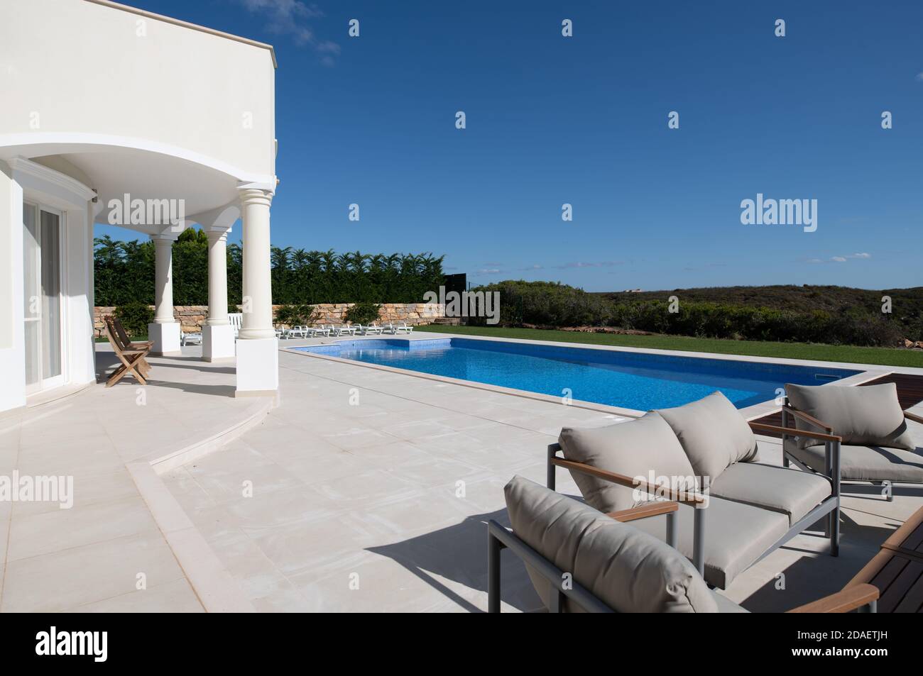 Großer Swimmingpool im Garten einer Luxusvilla An der algarve mit keramischen Fliesen und Sitzbereich Stockfoto