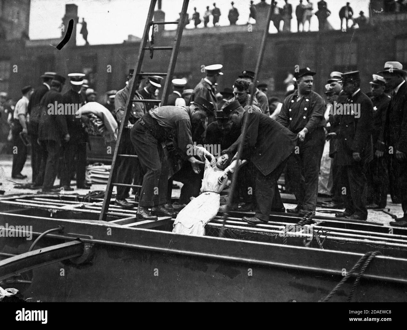 Männer, die nach der Katastrophe ein lebloses weibliches Opfer aus dem Deck der SS Eastland heben, Chicago, Illinois, 24. Juli 1915. Stockfoto