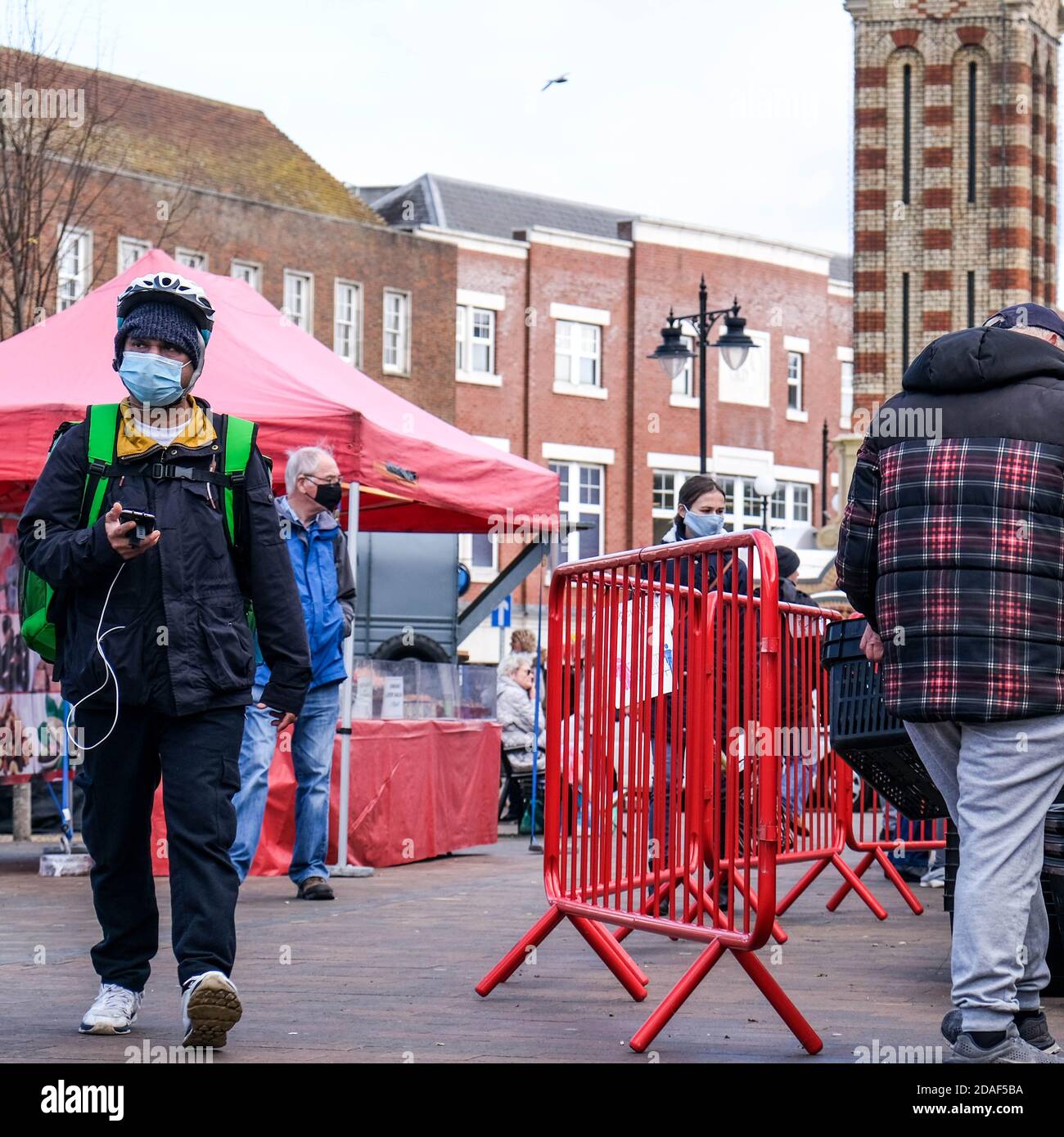 London UK, November 12 2020, Uber Eats Delivery Person Spaziergang durch einen Outdoor-Markt liefern Lebensmittel Stockfoto