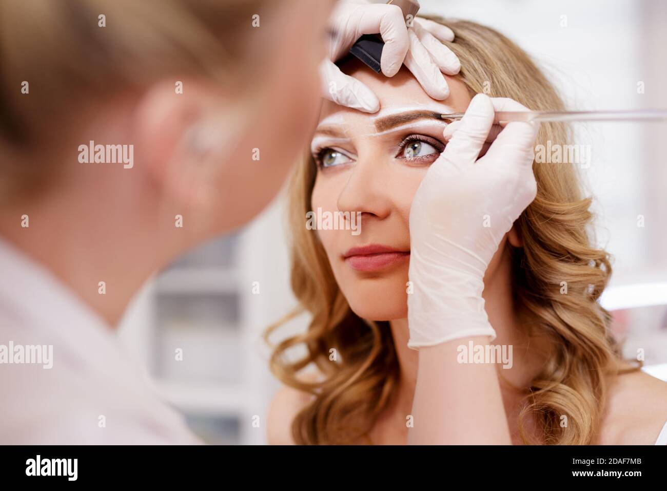 Make-up und Beauty-Konzept - Nahaufnahme von Make Up Künstler Malerei Augenbrauen Stockfoto