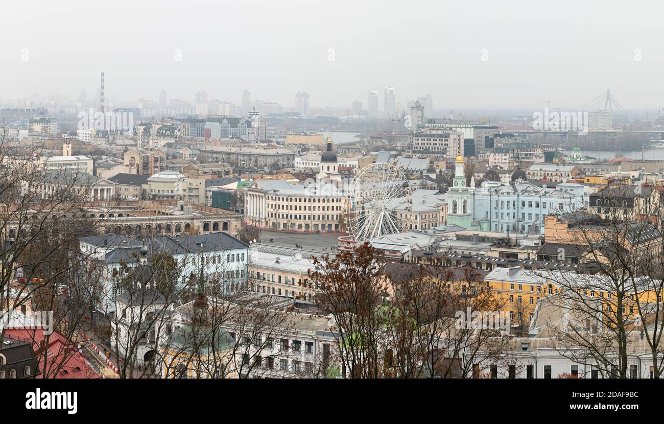 Kiew, Ukraine - 16. Nov. 2019: Stadtbild des Podol Bezirks in Kiew Stadt bei nebligen Tag. Kontraktova Platz, Kiew Mohyla Akademie und Riesenrad Stockfoto