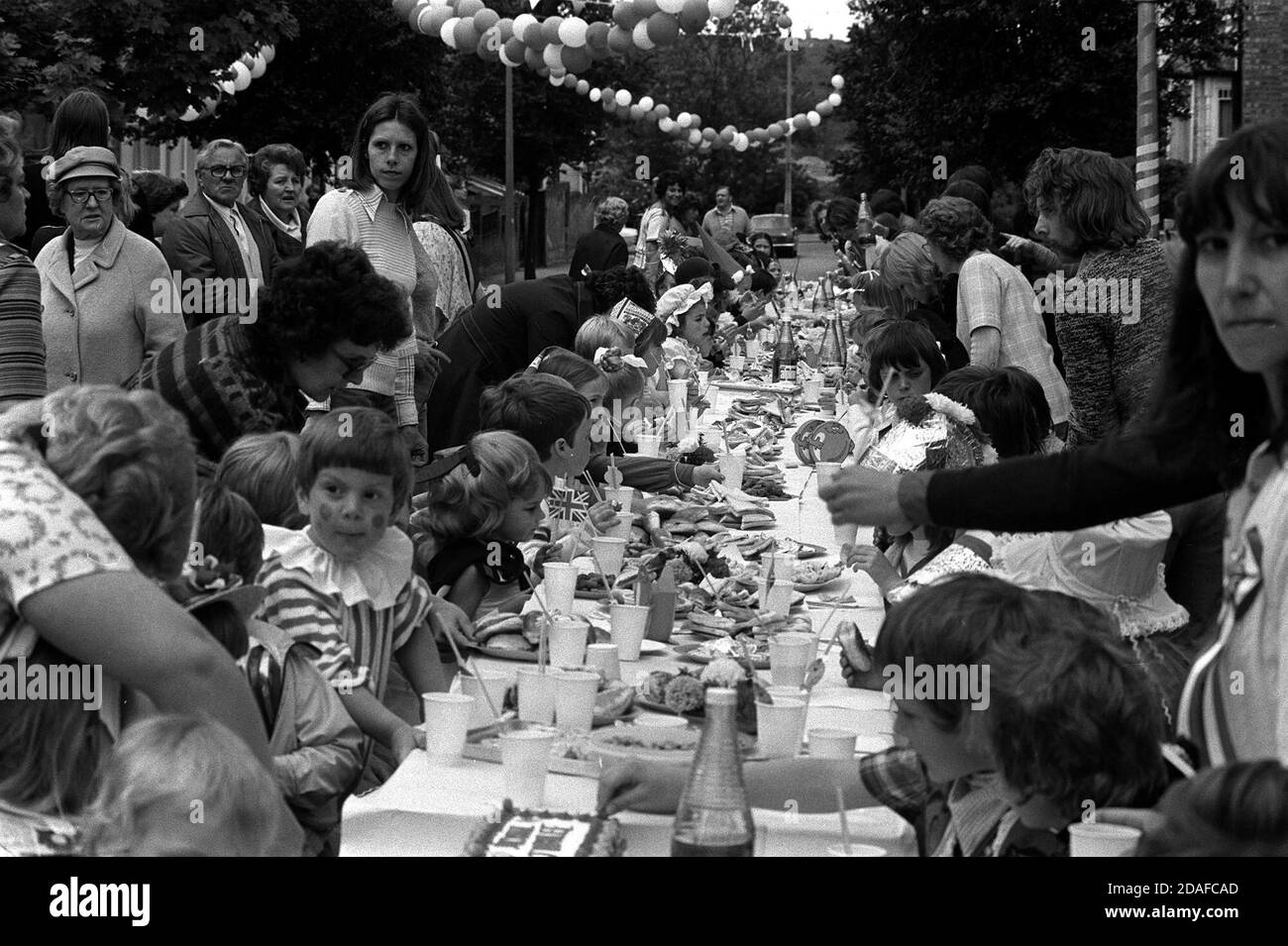 Datei Foto vom 01/06/77 von Bewohnern von Woodford Bridge, Essex, feiert Königin Elizabeth II Silber Jubilee mit einer Straßenparty für lokale Kinder. Stockfoto