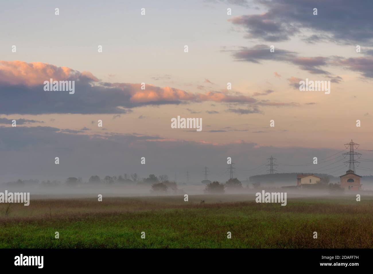 Nebel umhüllt die toskanische Landschaft in der Nähe von Pisa, Italien, kurz vor Sonnenuntergang Stockfoto