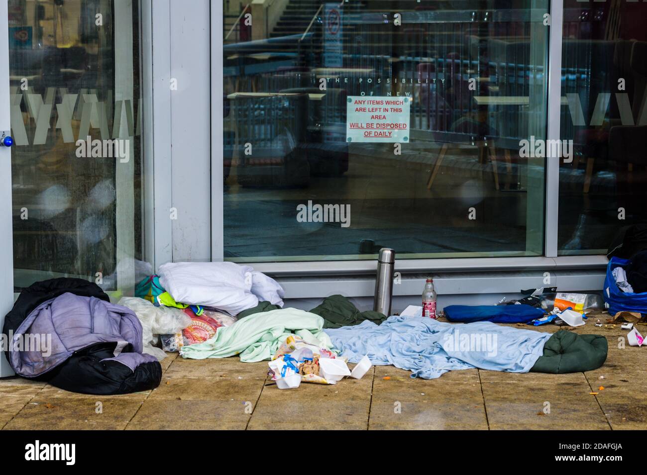 Die Habseligkeiten von jemandem, der rauh schlief, gingen auf der Straße zurück. Stockfoto